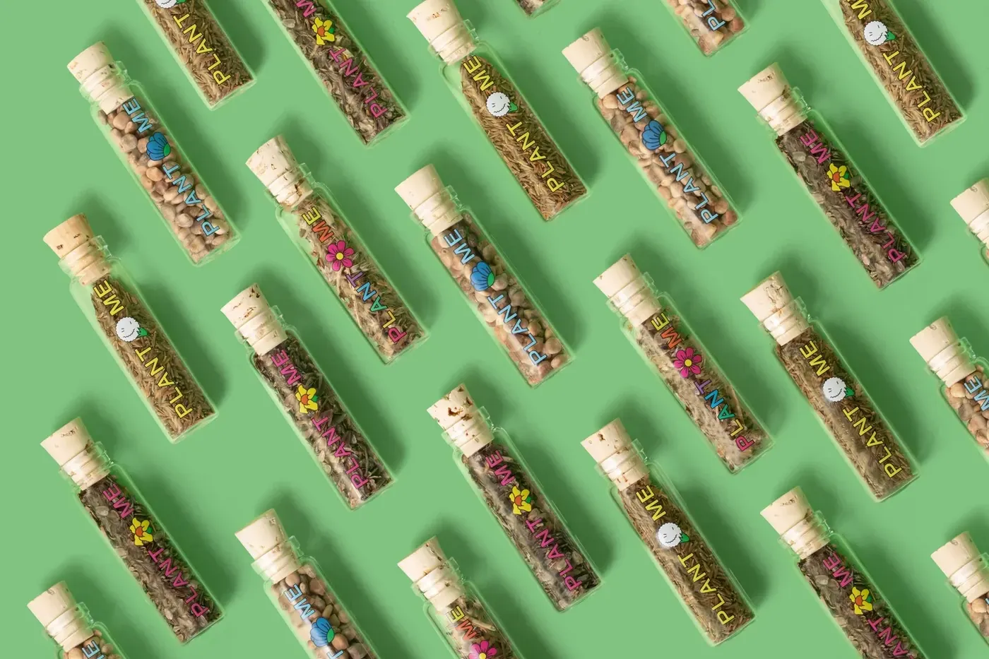 Rows of glass seed tubes laid out in a repeating pattern on a green background