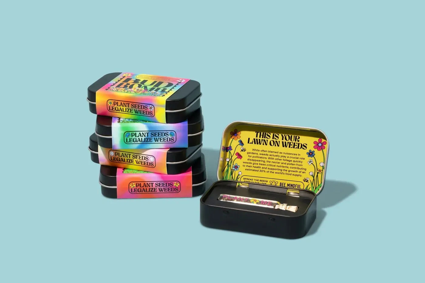 Two stacks of Legalize Weeds seed tins on a pale blue background, the top one open