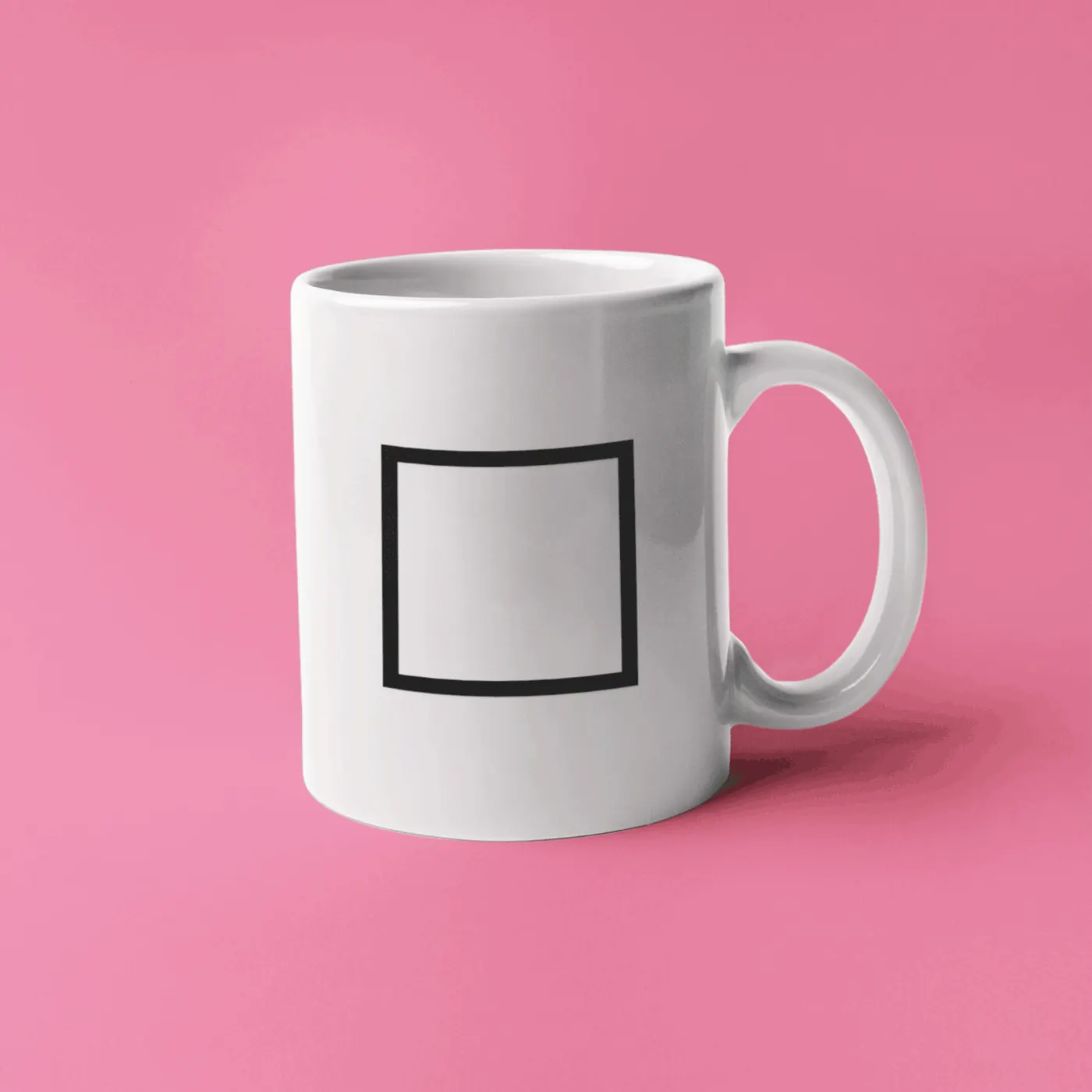A white ceramic mug with a black square outline on it, on a pink background